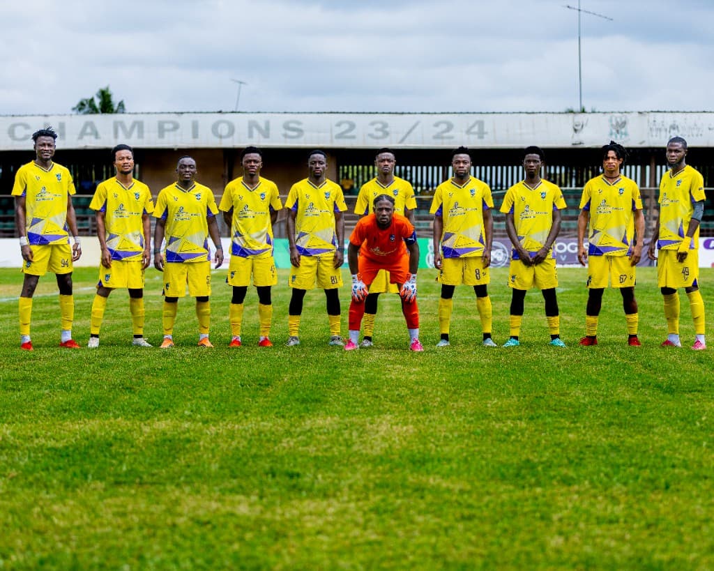 Medeama SC squad posing in yellow kits under a Champions 23/24 banner